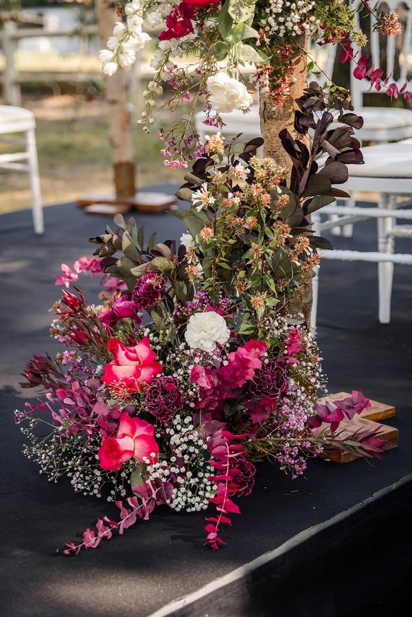 Floral arrangement at the base of a wooden arch